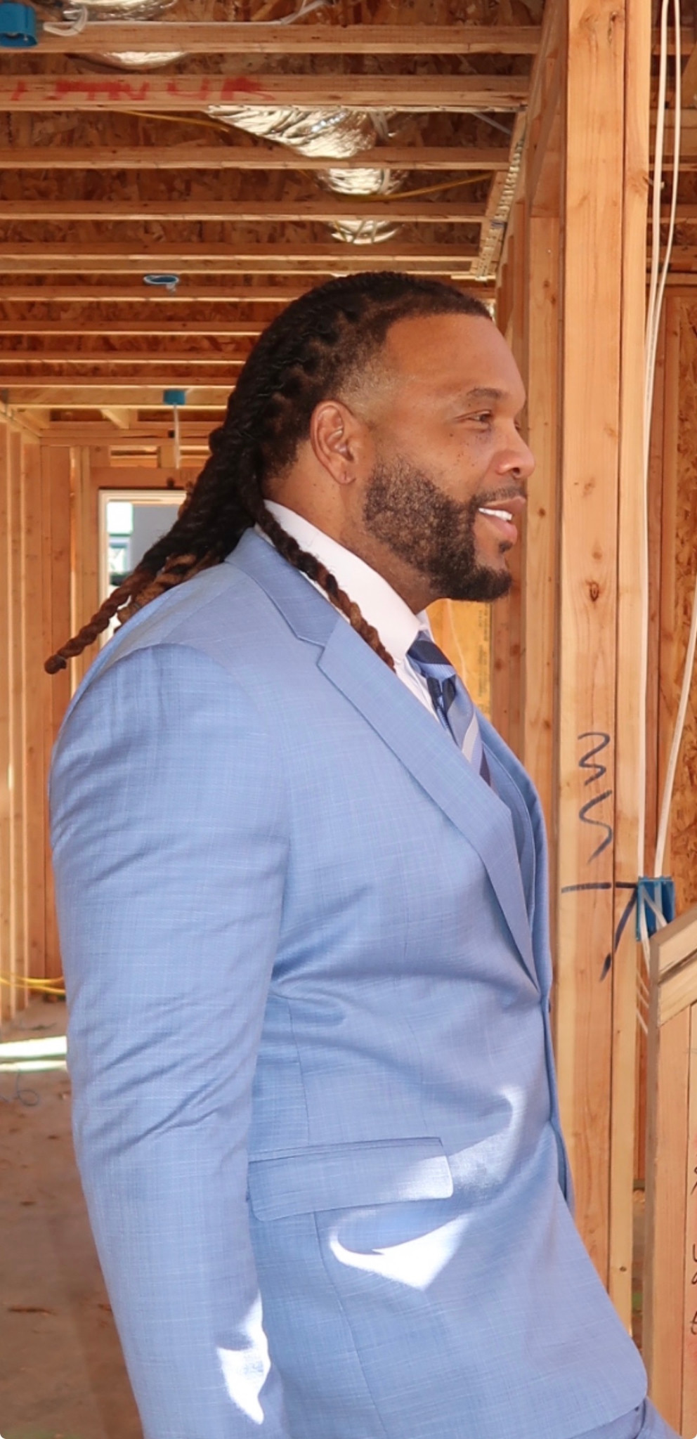 Side-profile portrait in a light blue suit
